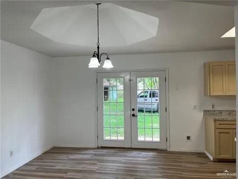 entryway with french doors, hardwood / wood-style floors, and an inviting chandelier