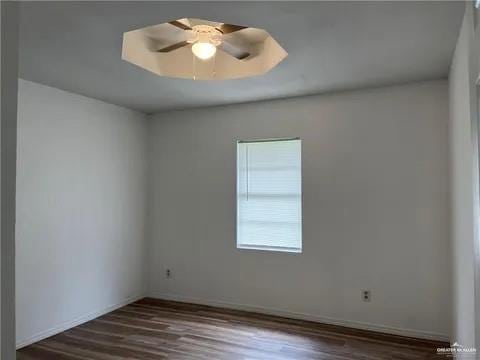 spare room with dark hardwood / wood-style floors and ceiling fan