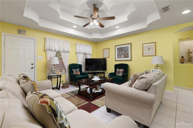 tiled living room with a raised ceiling, recessed lighting, a ceiling fan, and visible vents