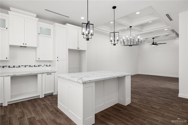 kitchen featuring white cabinetry, hanging light fixtures, light stone counters, and a kitchen island