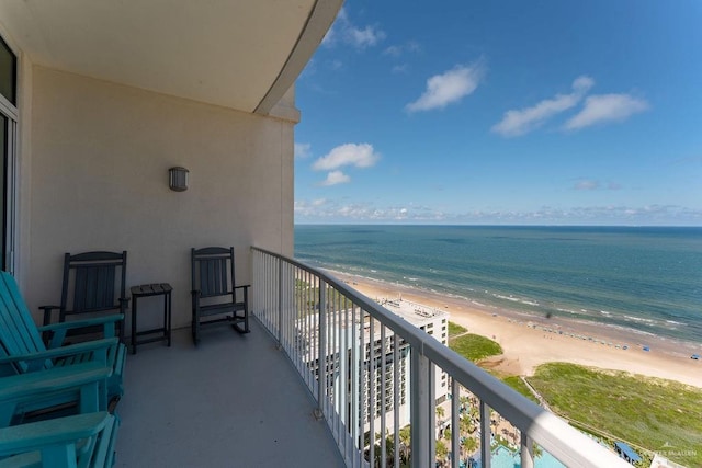 balcony with a water view and a view of the beach