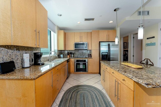 kitchen with stone countertops, stainless steel appliances, light tile patterned floors, and sink