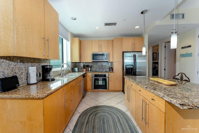 310 Padre Blvd Unit 2306, South Padre Island, TX 78597 - kitchen featuring appliances with stainless steel finishes, light stone countertops, backsplash, light tile patterned floors, and a center island