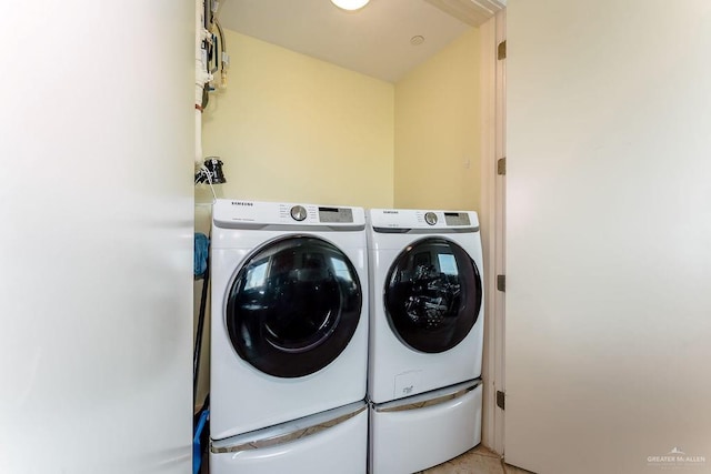 laundry area featuring washer and clothes dryer and light tile patterned floors