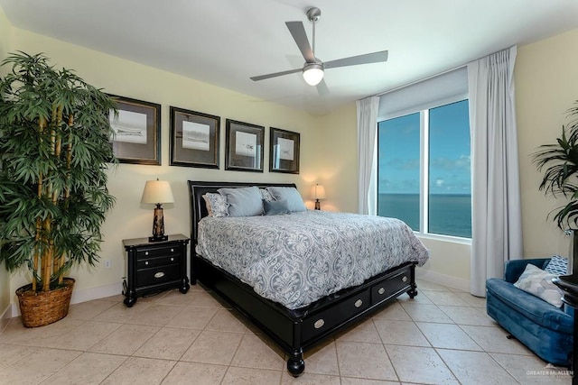 bedroom featuring ceiling fan, a water view, and light tile patterned floors