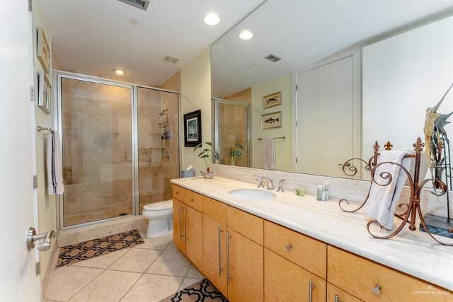 bathroom with tile patterned flooring, vanity, toilet, and an enclosed shower