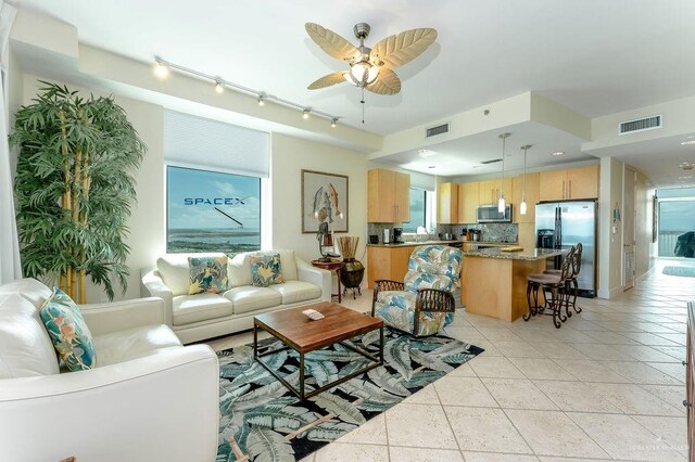 tiled living room featuring ceiling fan, a healthy amount of sunlight, and track lighting