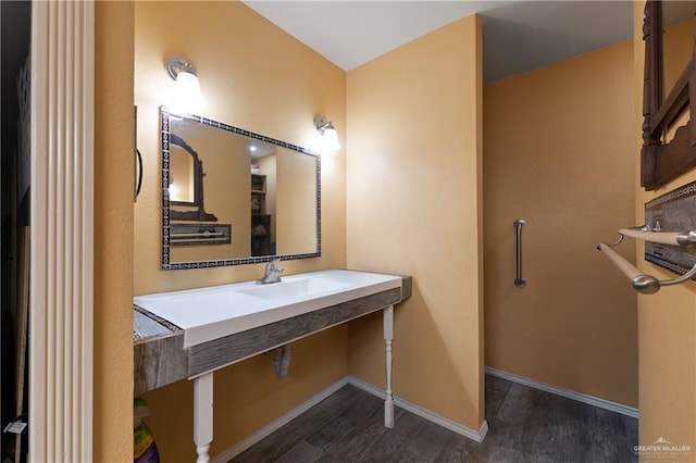 bathroom with a sink, baseboards, and wood finished floors