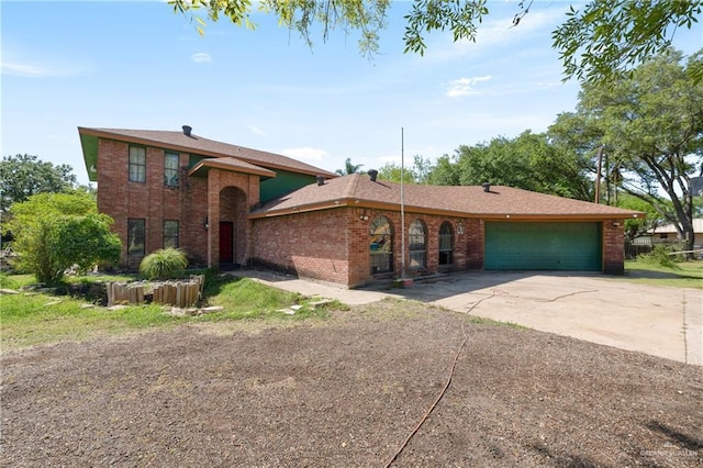traditional-style home featuring an attached garage, concrete driveway, and brick siding