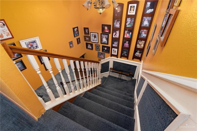 staircase with an inviting chandelier