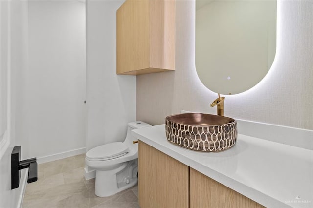 bathroom featuring vanity, tile patterned floors, and toilet