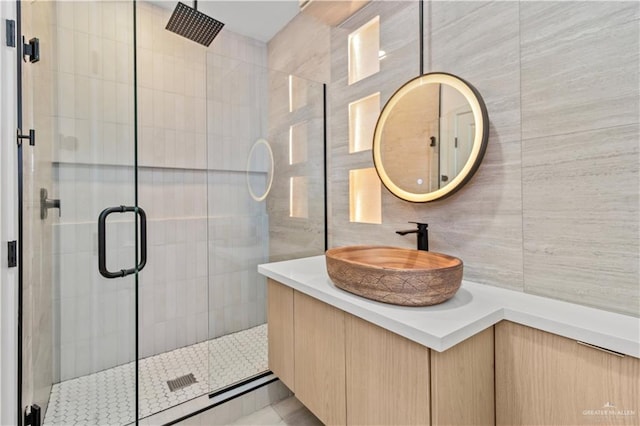 bathroom featuring tile walls, backsplash, vanity, and walk in shower