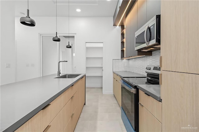 kitchen featuring appliances with stainless steel finishes, decorative light fixtures, sink, and light brown cabinets