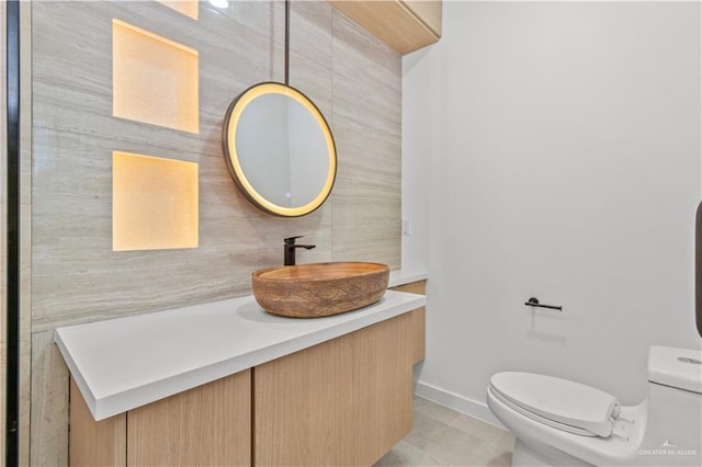 bathroom with tile patterned flooring, vanity, and toilet