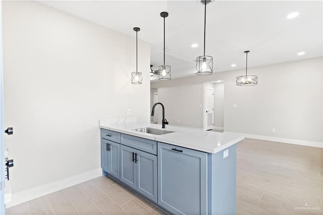 kitchen featuring sink, hanging light fixtures, light stone counters, kitchen peninsula, and light wood-type flooring