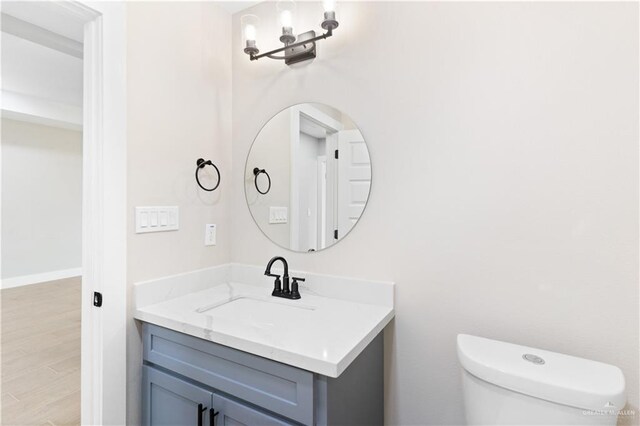 bathroom featuring hardwood / wood-style floors, vanity, and toilet