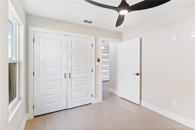 unfurnished bedroom with multiple windows, ceiling fan, a closet, and light hardwood / wood-style floors