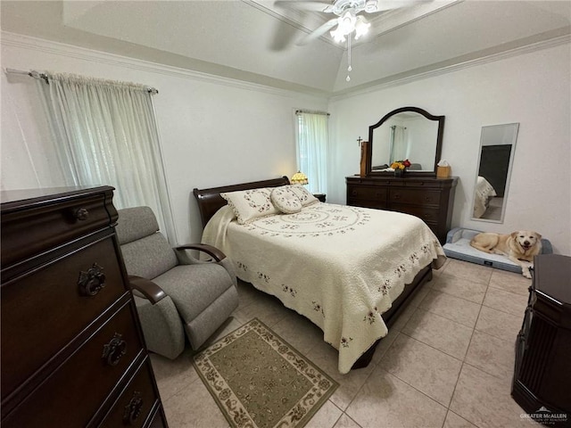 bedroom with light tile patterned flooring, a tray ceiling, ornamental molding, and a ceiling fan