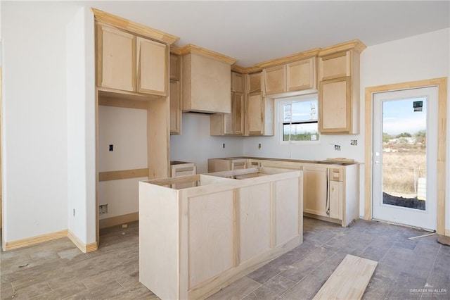 kitchen with light brown cabinetry and a center island