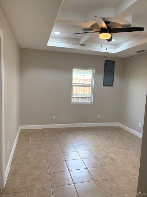 empty room with electric panel, a raised ceiling, ceiling fan, and light tile patterned flooring