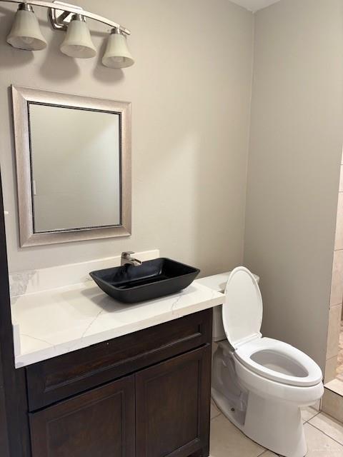 bathroom featuring vanity, tile patterned floors, and toilet