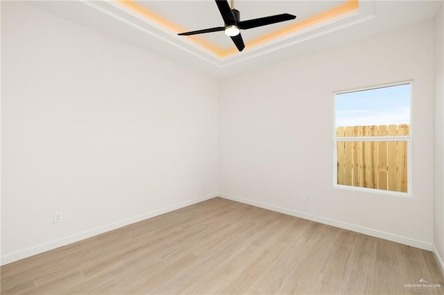 4909 Columbia Ave, Mcallen, TX 78504 - empty room with a tray ceiling, light wood-type flooring, a ceiling fan, and baseboards