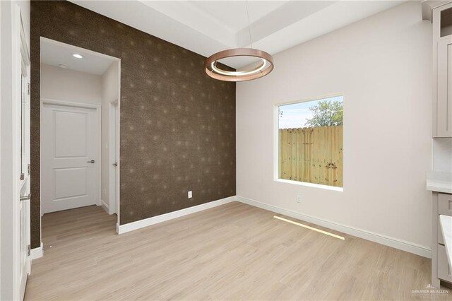 4909 Columbia Ave, Mcallen, TX 78504 - unfurnished dining area featuring an accent wall, baseboards, wallpapered walls, and light wood finished floors