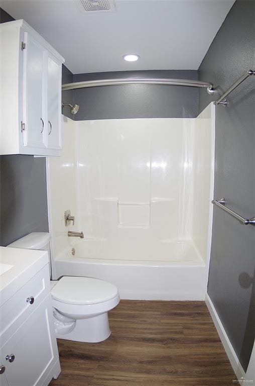 full bathroom featuring hardwood / wood-style floors, vanity, bathing tub / shower combination, and toilet