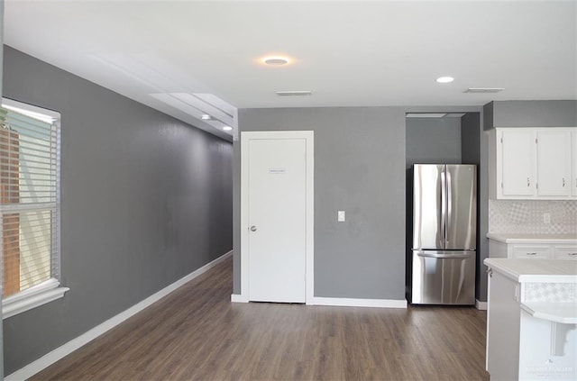 kitchen with white cabinets, stainless steel fridge, dark hardwood / wood-style floors, and a wealth of natural light