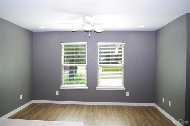 spare room featuring ceiling fan and dark wood-type flooring