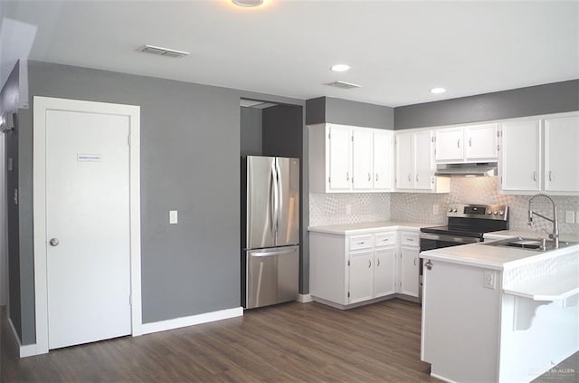 kitchen with white cabinetry, sink, dark wood-type flooring, tasteful backsplash, and appliances with stainless steel finishes