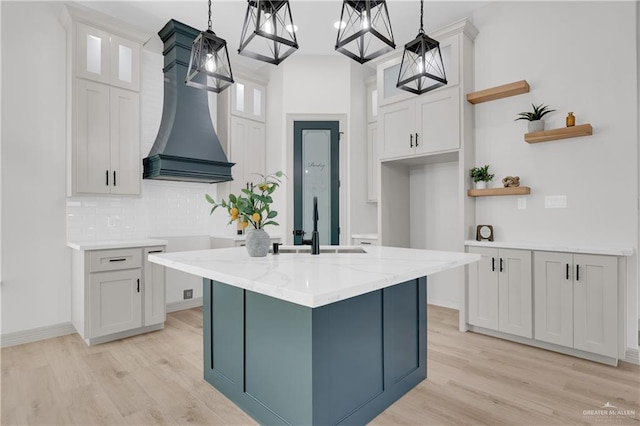 kitchen featuring open shelves, light wood-type flooring, a sink, and white cabinetry