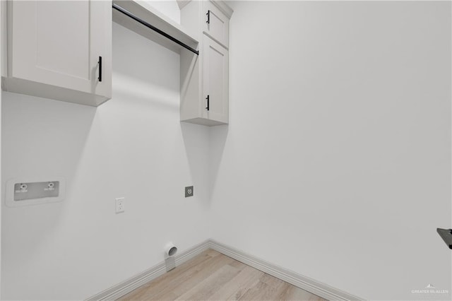 clothes washing area featuring baseboards, cabinet space, electric dryer hookup, and light wood finished floors