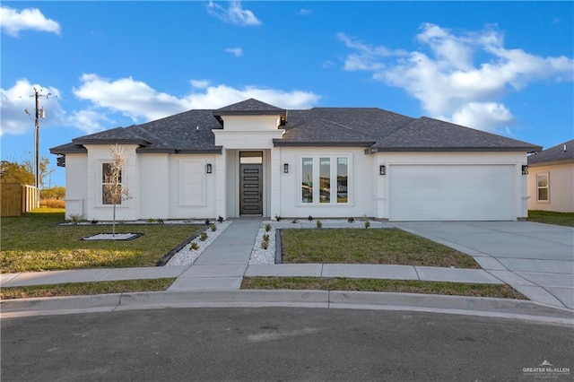 view of front of home featuring an attached garage, driveway, a front lawn, and stucco siding