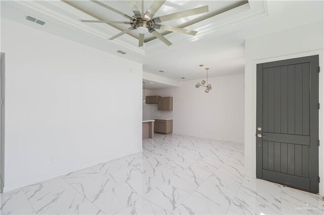 spare room featuring a raised ceiling and ceiling fan