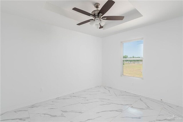 unfurnished room featuring a tray ceiling and ceiling fan