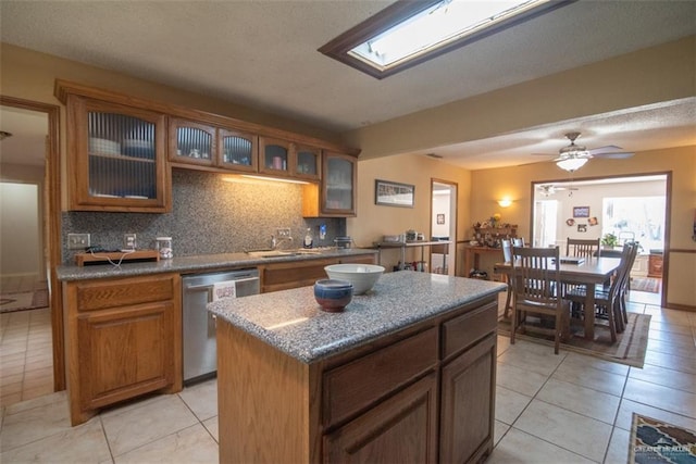 2517 E Mile 4th Rd, Mission, TX 78573 - kitchen with stainless steel dishwasher, decorative backsplash, light tile patterned flooring, and brown cabinets