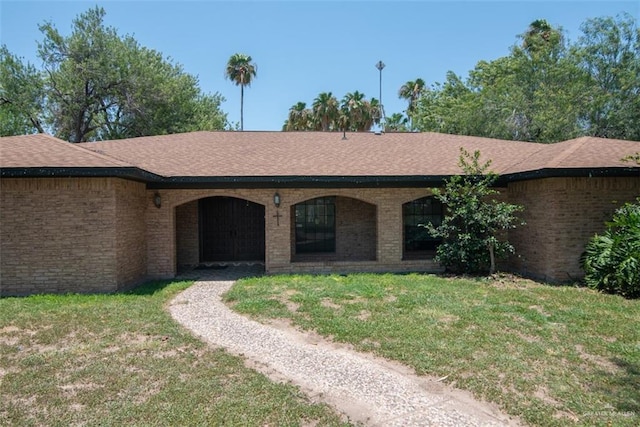 2517 E Mile 4th Rd, Mission, TX 78573 - view of front of home with a front yard, brick siding, and a shingled roof