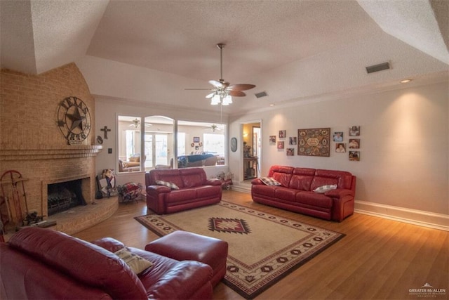 2517 E Mile 4th Rd, Mission, TX 78573 - living area featuring a textured ceiling, wood finished floors, baseboards, ceiling fan, and a brick fireplace