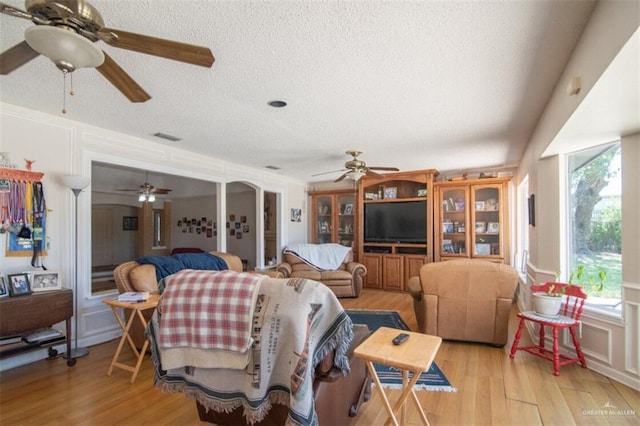 2517 E Mile 4th Rd, Mission, TX 78573 - living area with ceiling fan, a textured ceiling, plenty of natural light, light wood-type flooring, and a decorative wall