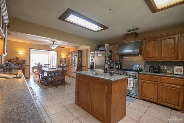 2517 E Mile 4th Rd, Mission, TX 78573 - kitchen featuring wall chimney exhaust hood, stainless steel appliances, brown cabinets, and a center island