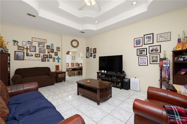 tiled living room featuring a tray ceiling and ceiling fan