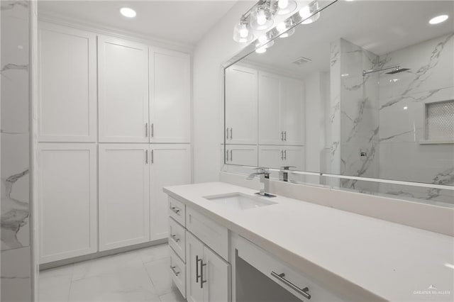 bathroom featuring a tile shower and vanity