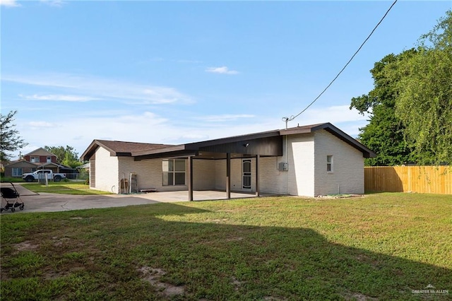 back of property featuring a yard and a patio