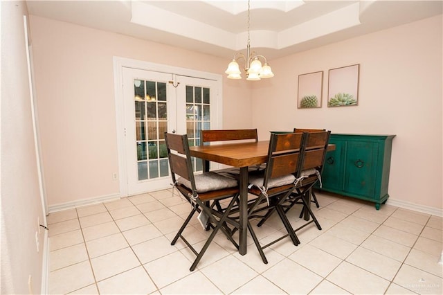 dining area with french doors, light tile patterned floors, and a raised ceiling