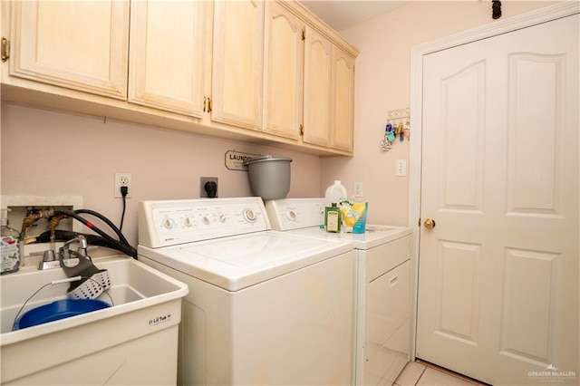 washroom with sink, washer and clothes dryer, and cabinets