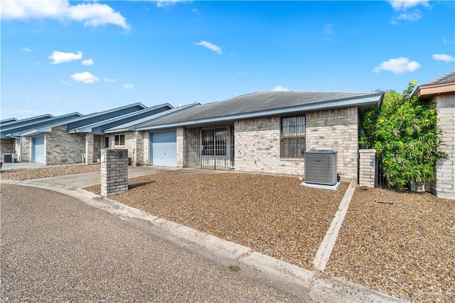 1923 Stadler Dr, Mission, TX 78572 - view of front of home with cooling unit, a garage, driveway, and brick siding