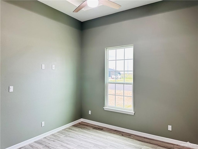 spare room with baseboards, a ceiling fan, and wood finished floors