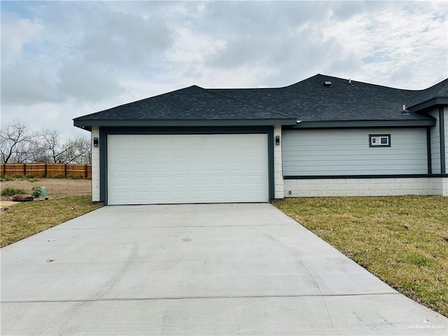 exterior space with roof with shingles, driveway, an attached garage, and fence