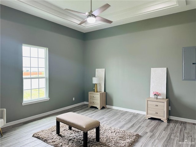 sitting room featuring electric panel, ceiling fan, light wood finished floors, and baseboards